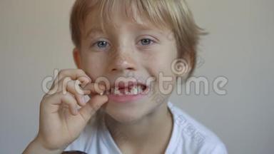 小男孩显示他的一些乳齿脱落了。 儿童牙齿变化的概念